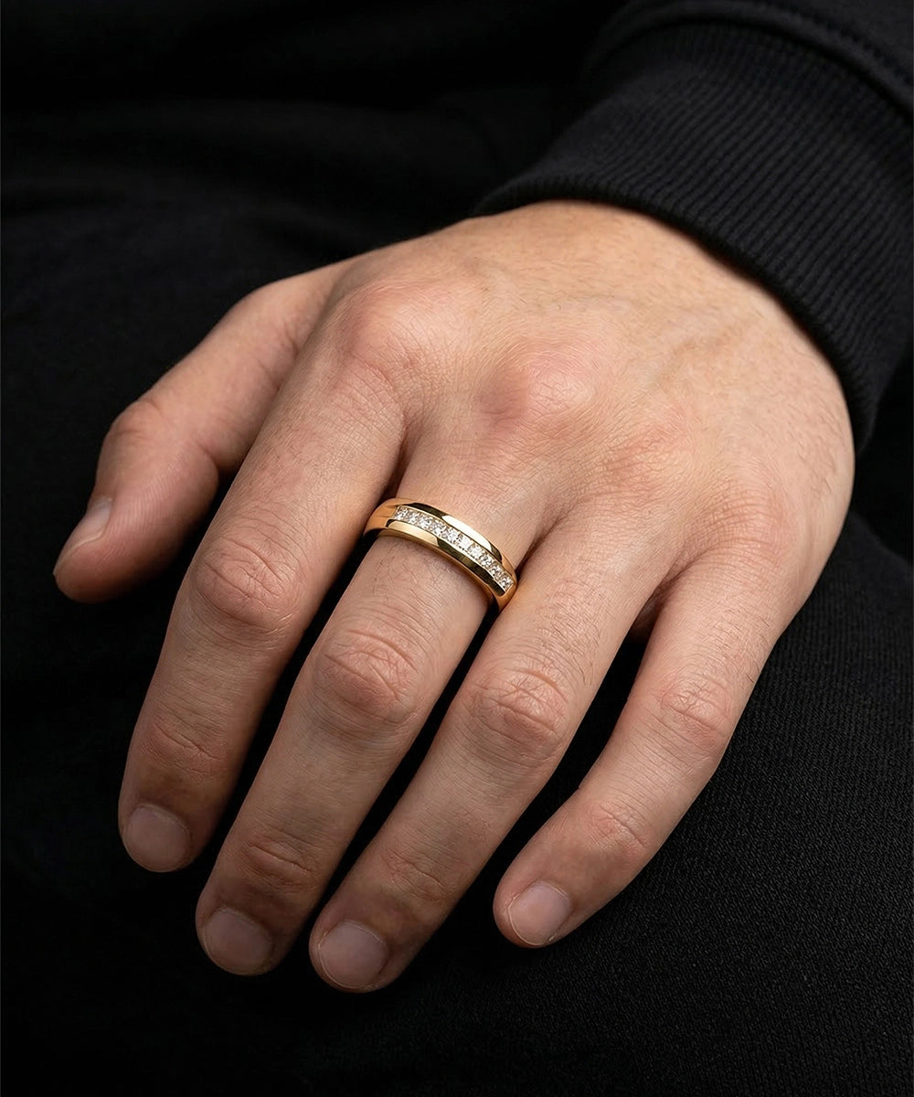 Hand wearing a silver ring with black background