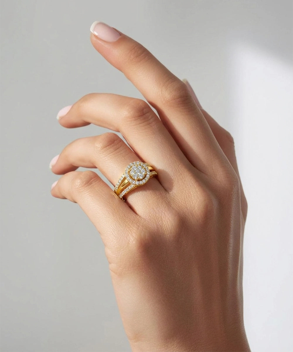 Hand wearing a gold ring with a diamond on a neutral background