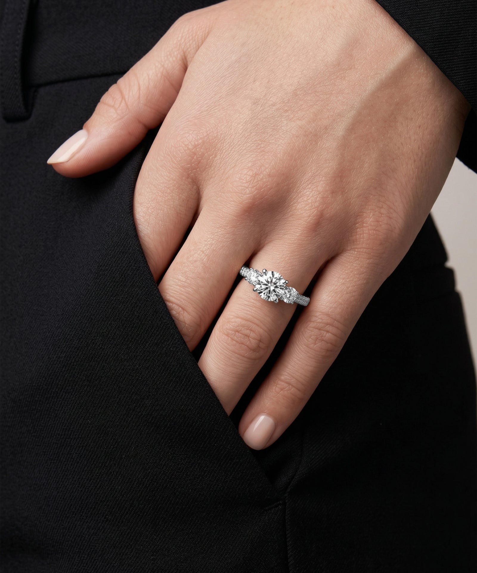 Hand wearing a diamond ring with a blurred background