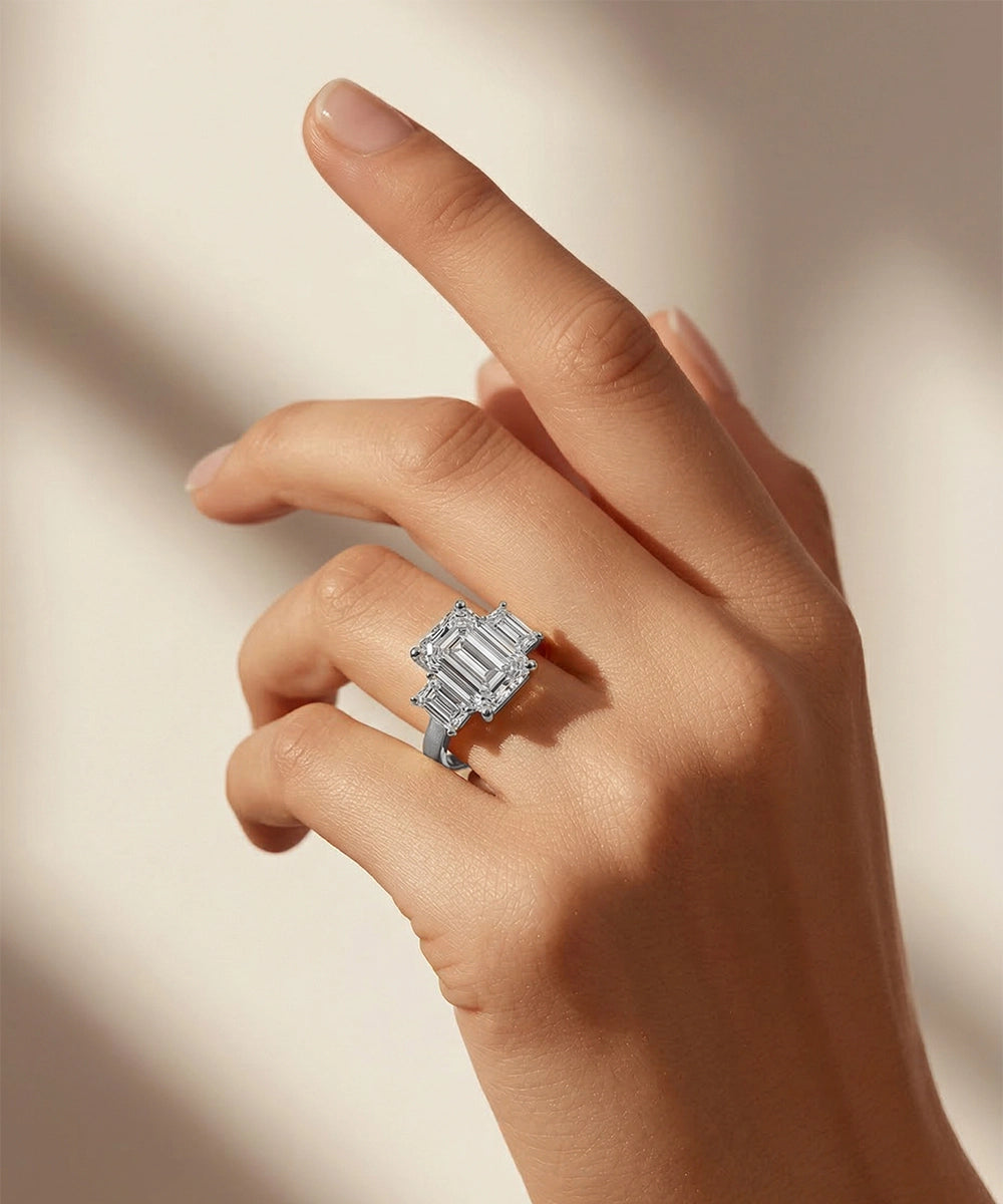 Hand wearing a diamond ring on a neutral background