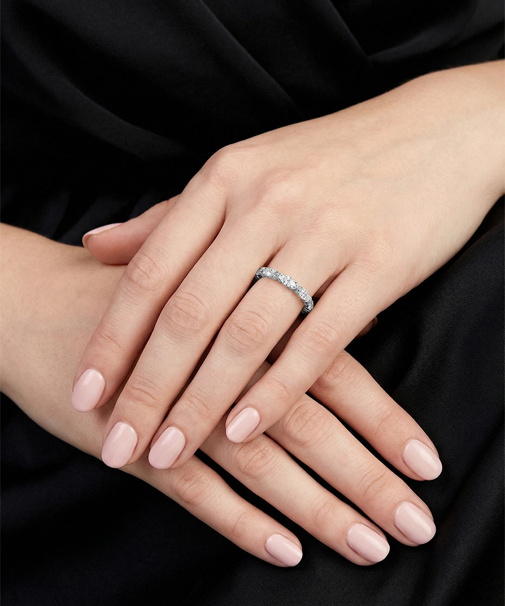 Close-up of hands with a diamond ring on a black background