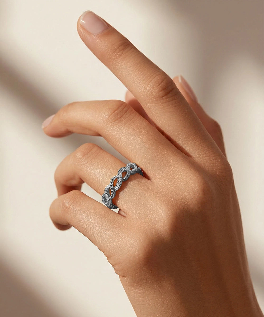 Hand wearing a silver ring with a blurred background