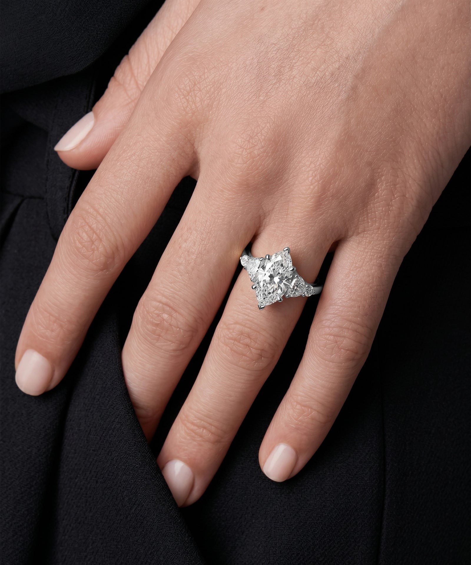 Diamond ring on a hand against a black background