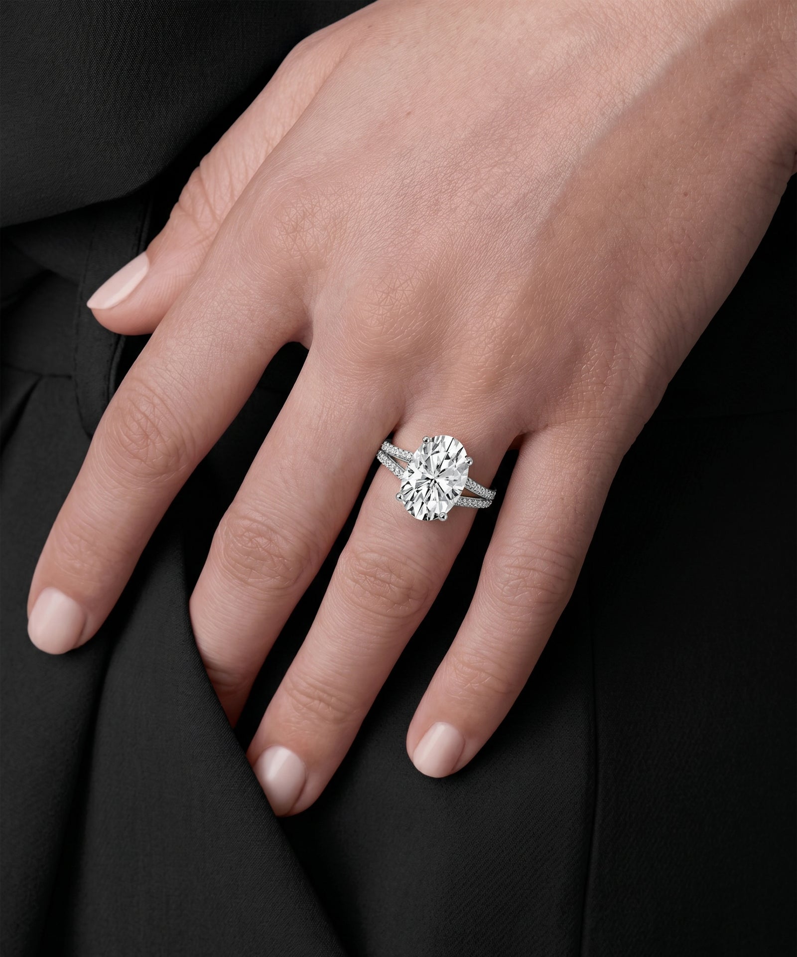 Close-up of a hand wearing a diamond ring on a black background