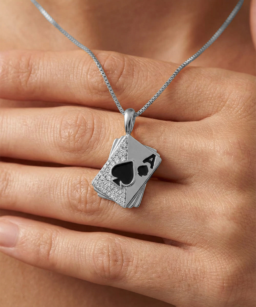 Silver pendant shaped like a playing card with a spade symbol on a hand.