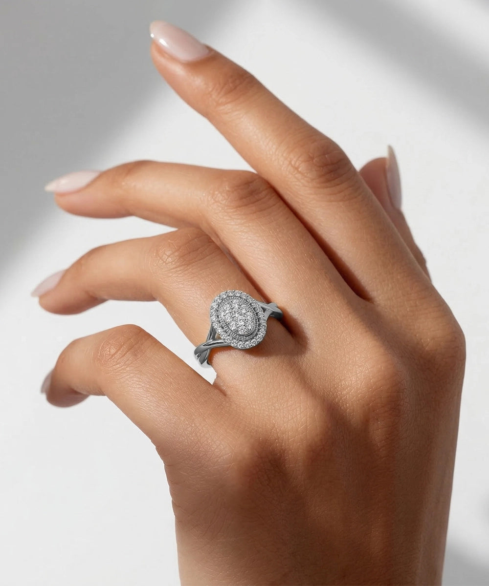 Hand wearing a silver ring with a diamond design on a neutral background