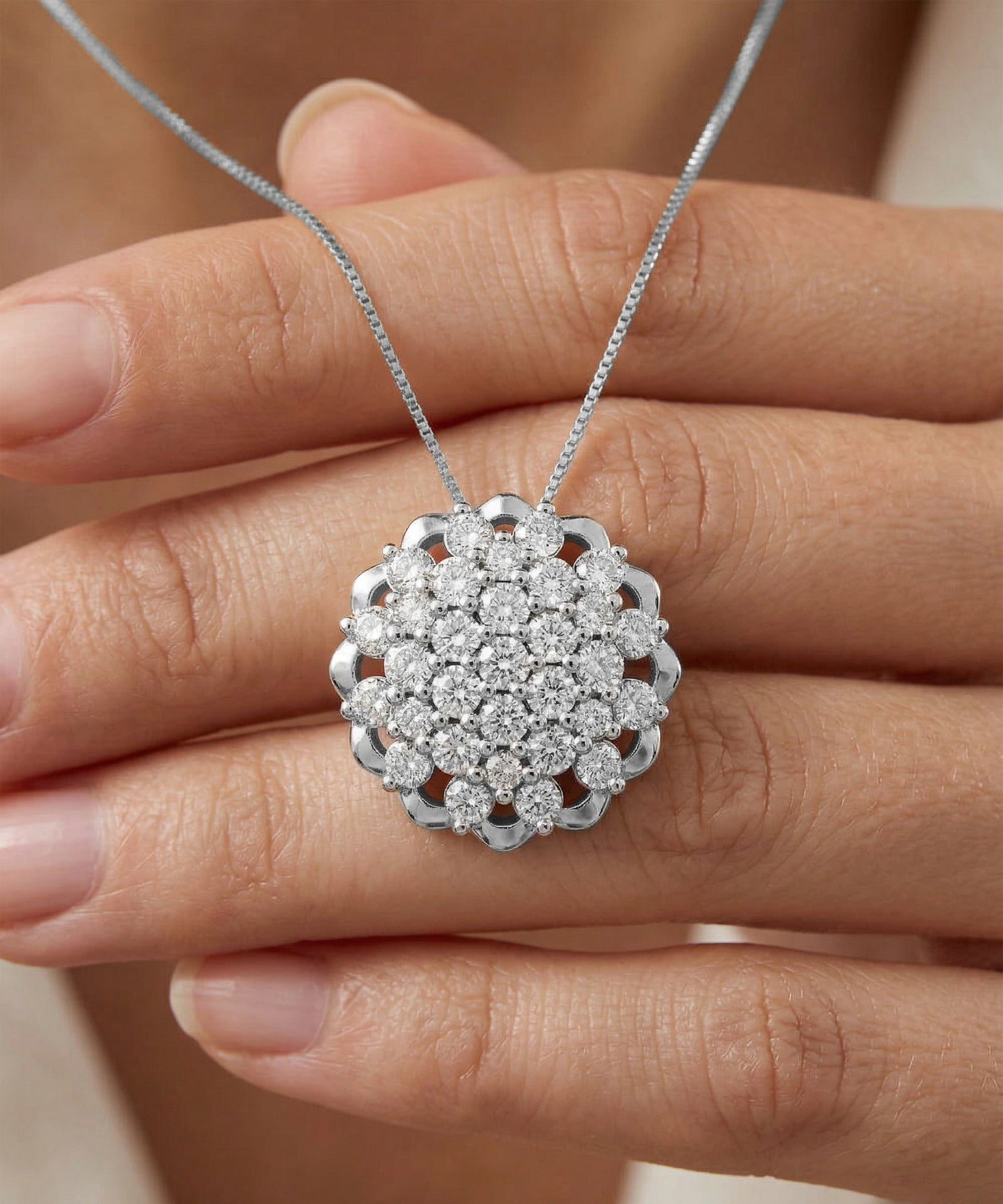 Silver necklace with a diamond pendant held by a hand against a neutral background