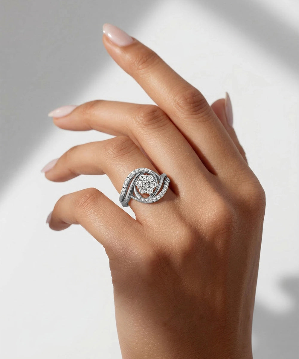 Hand wearing a silver ring with a diamond design on a neutral background