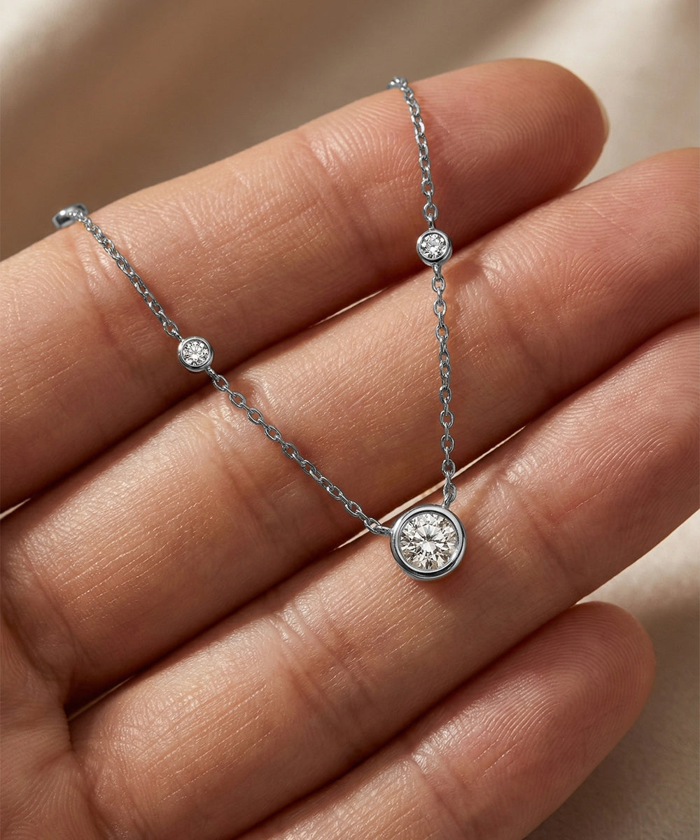 Silver bracelet with diamond accents on a hand against a neutral background