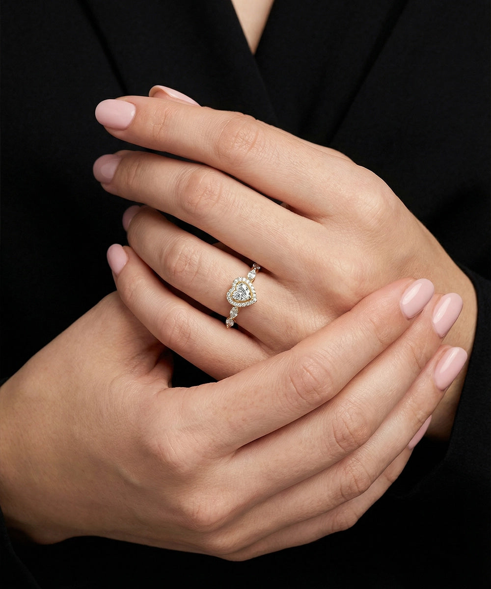 Close-up of a hand wearing a diamond ring with a black background