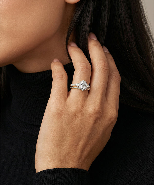 Close-up of a hand wearing a diamond ring with a blurred background