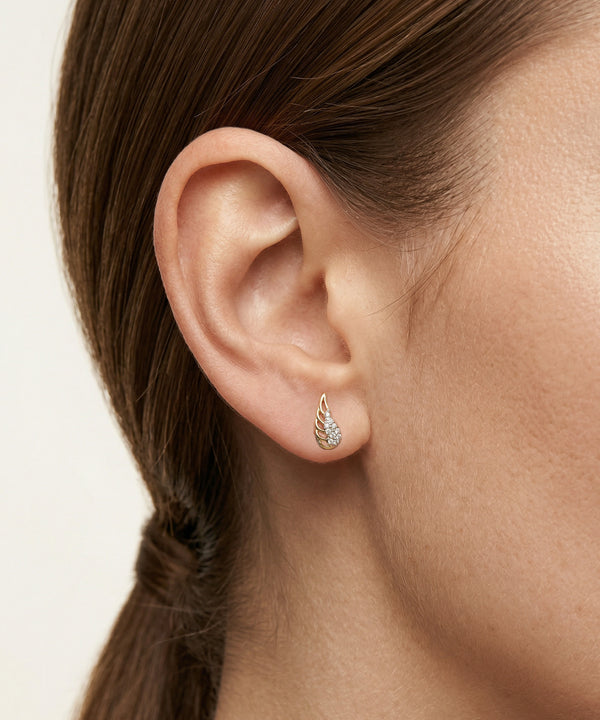 Close-up of an ear wearing a diamond earring with a blurred background