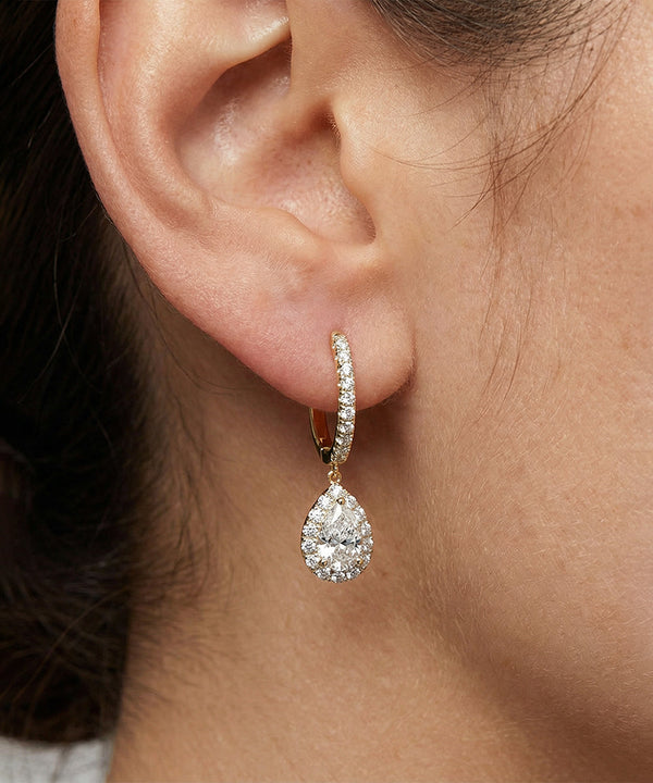 Teardrop-shaped diamond earring worn by a person