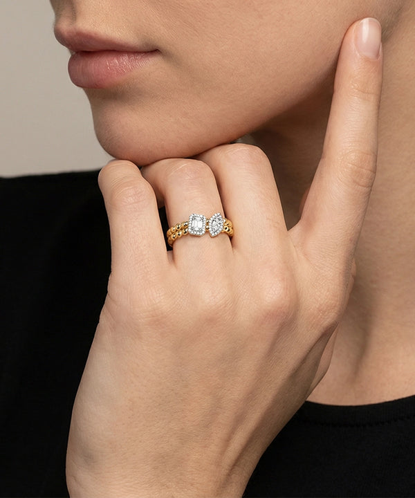 Close-up of a hand wearing a diamond ring with a neutral background