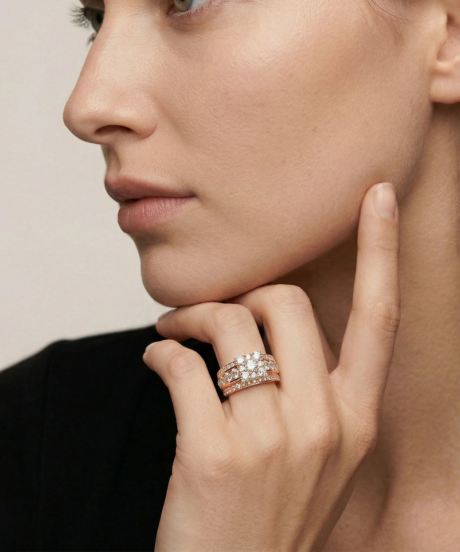 Close-up of a woman's hand wearing a diamond ring with a neutral background