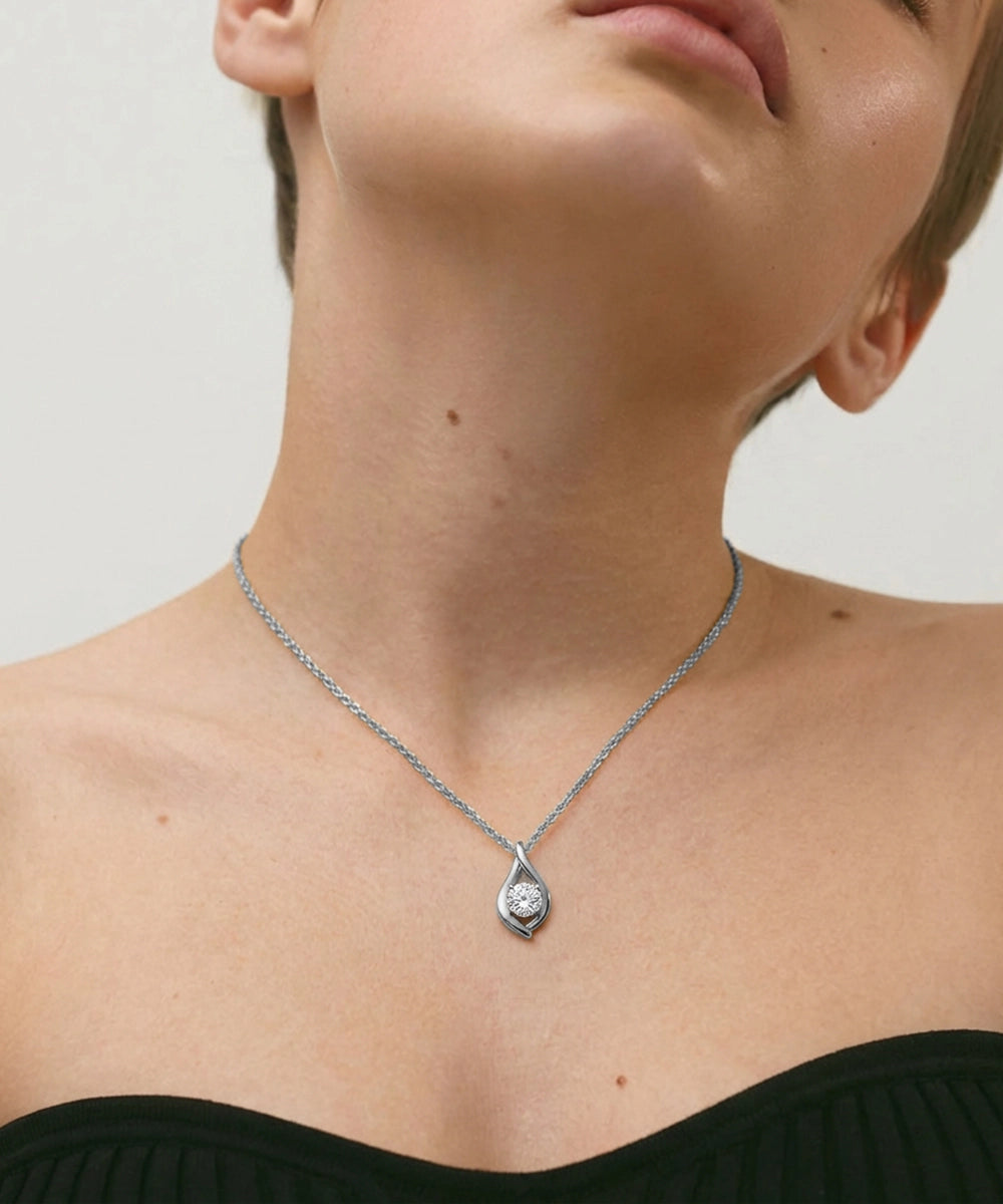 Necklace with a pendant worn by a person against a neutral background