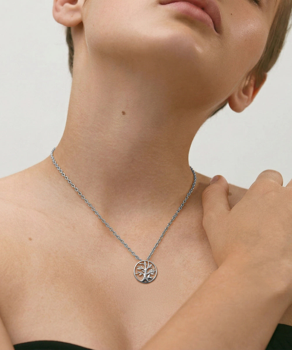 Necklace with a tree-of-life pendant worn by a person on a neutral background