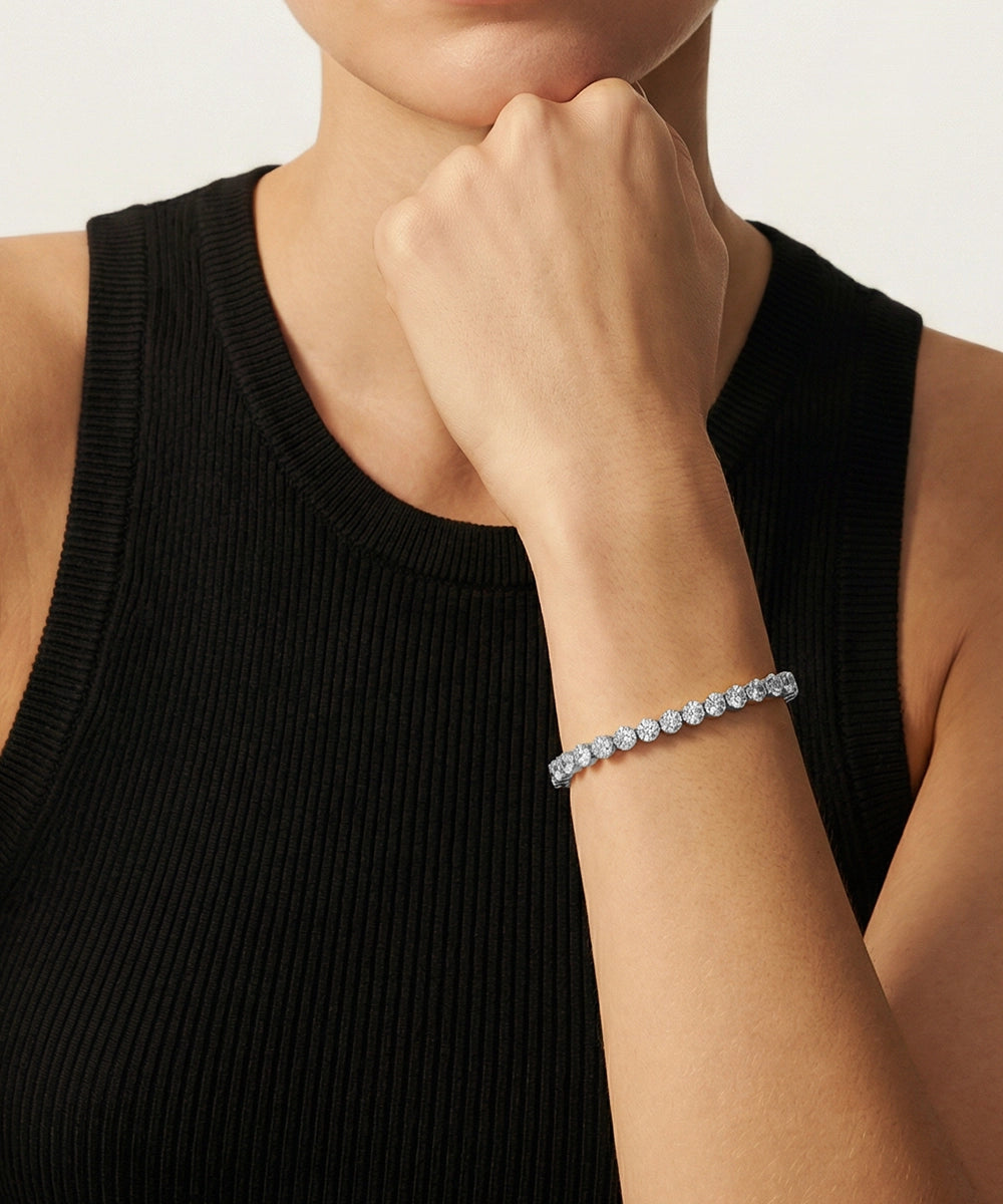 Person wearing a gold bracelet with a plain background