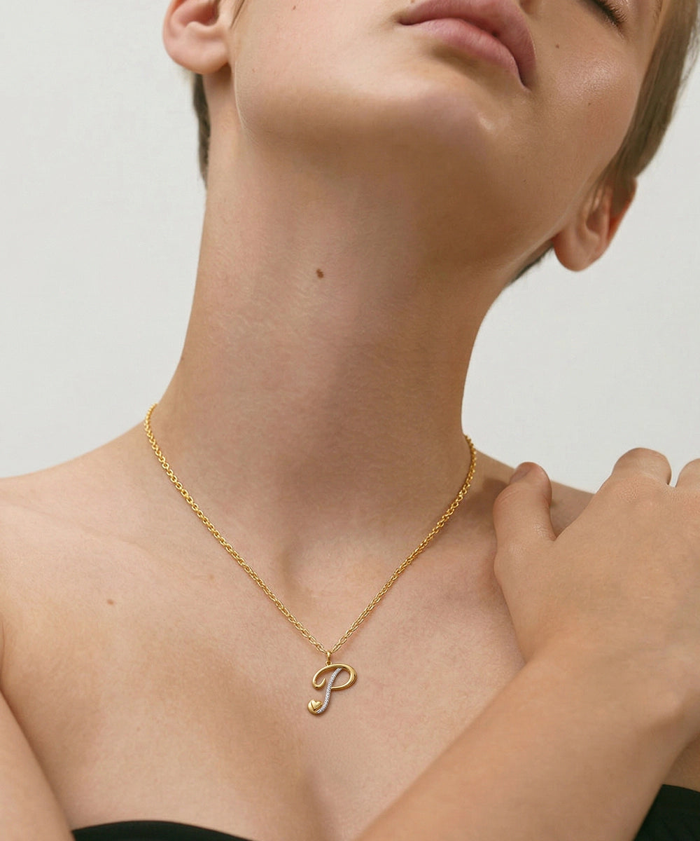 Gold necklace with a letter 'P' pendant on a neutral background