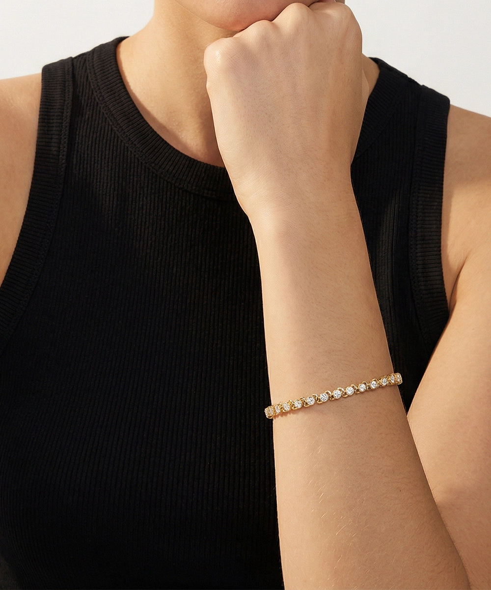 Person wearing a delicate bracelet on a plain background