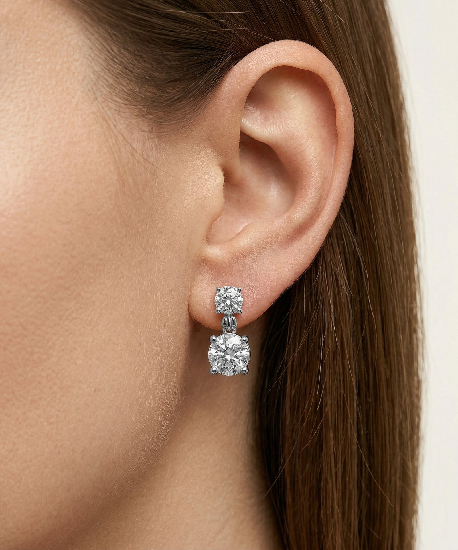 Close-up of a woman's ear wearing a diamond earring.