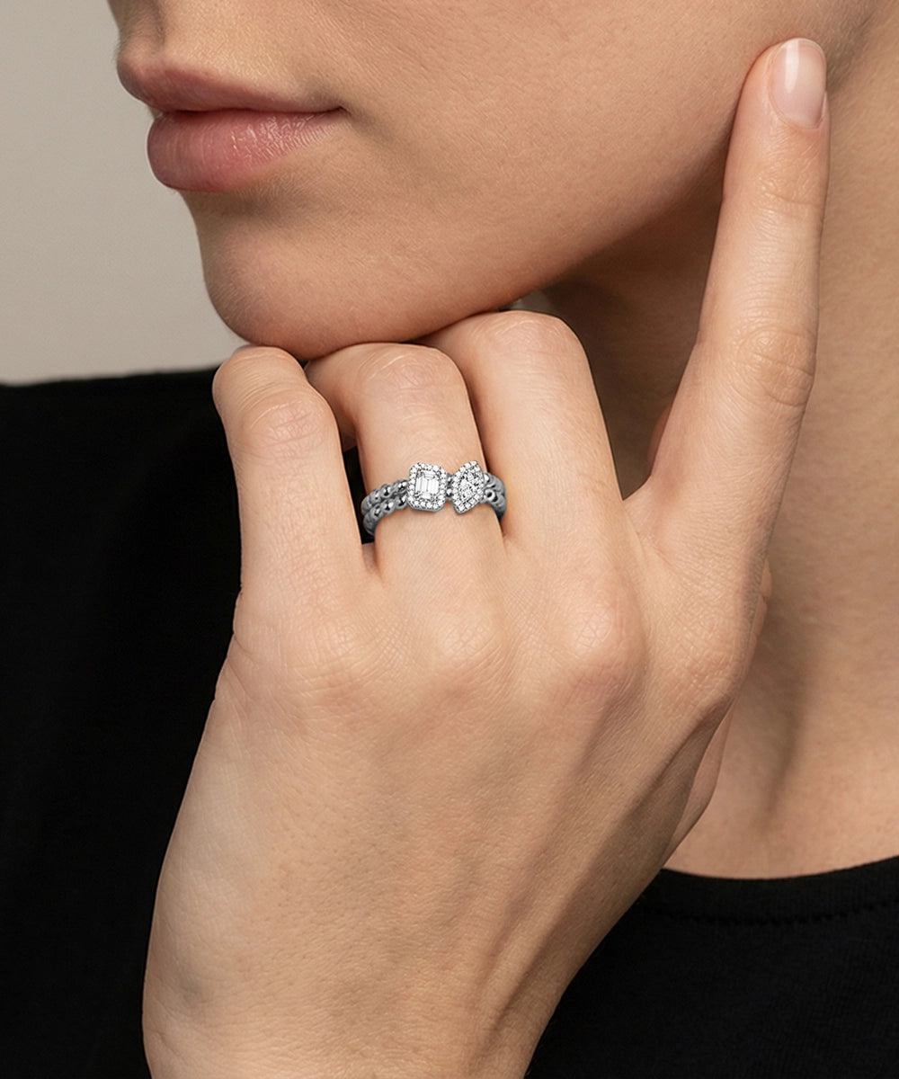 Close-up of a hand wearing a diamond ring with a neutral background