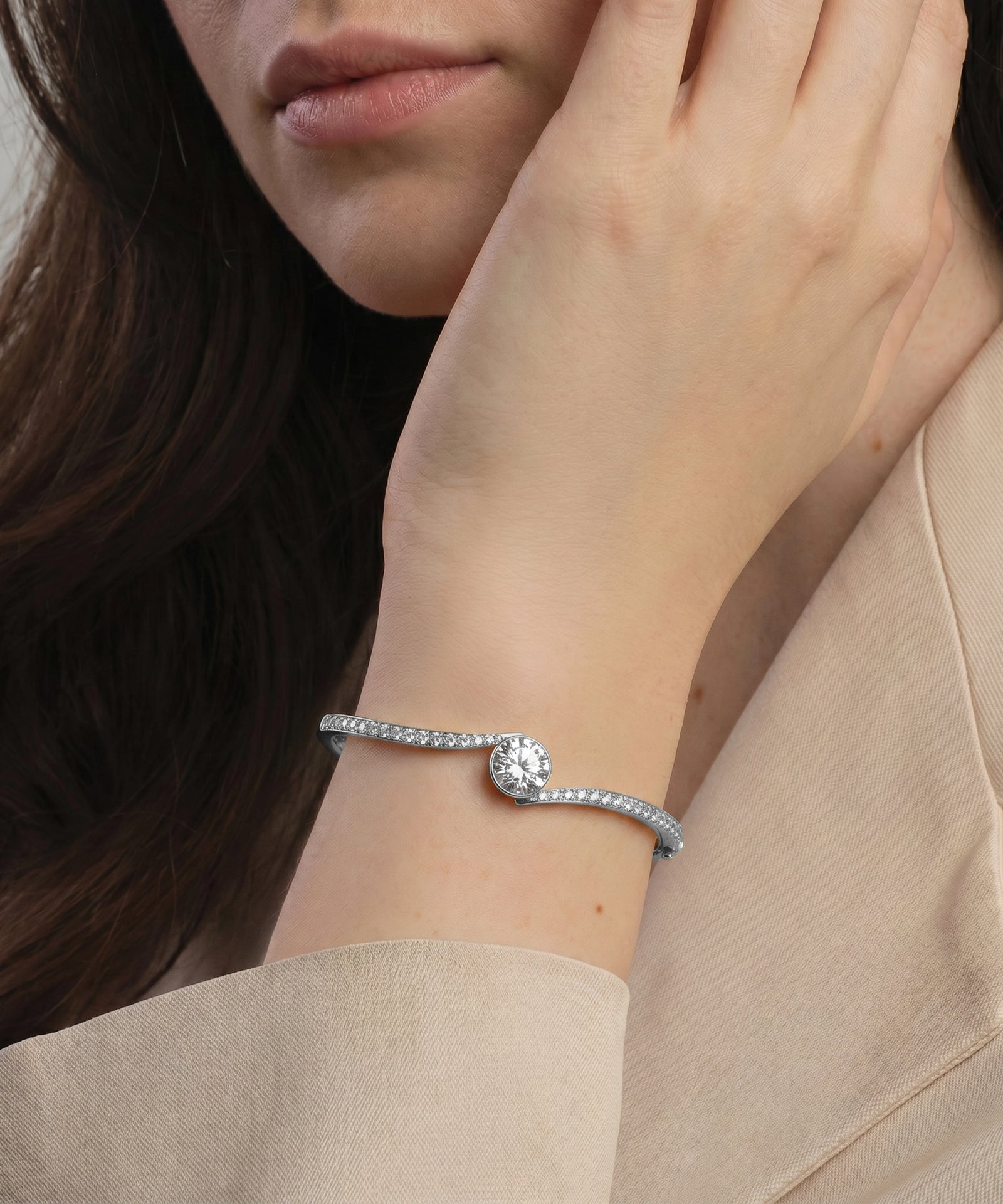 Close-up of a woman's wrist wearing a silver bracelet with a heart charm.