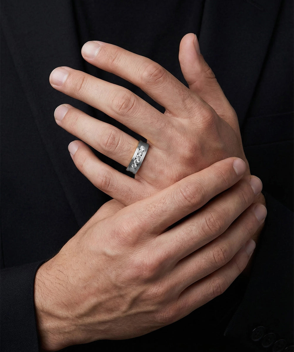 Close-up of a hand wearing a silver ring with a dark background