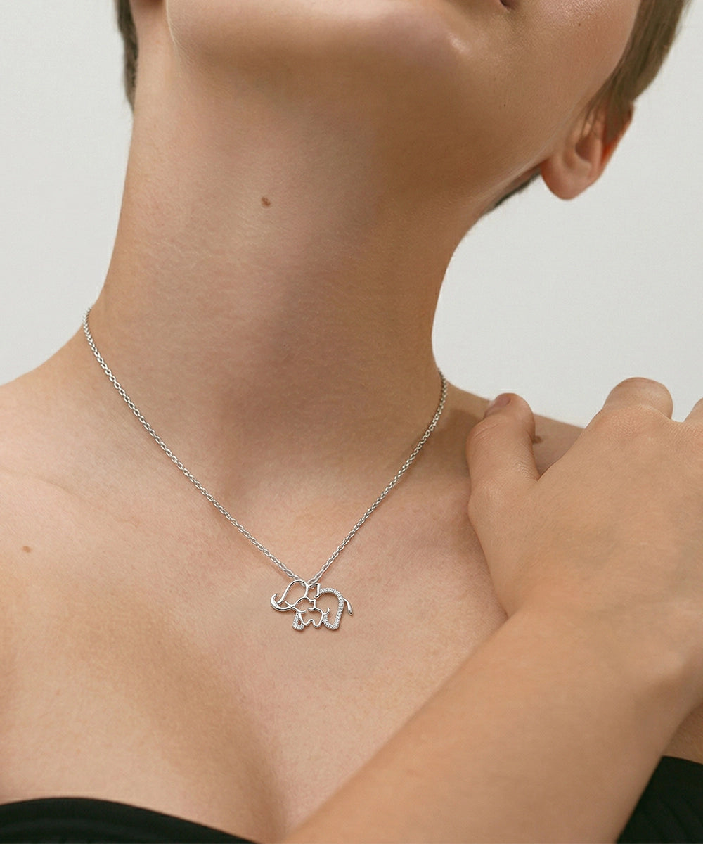 Person wearing a silver necklace with a bear pendant on a neutral background