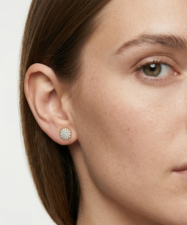 Close-up of a woman wearing a round earring with a white background