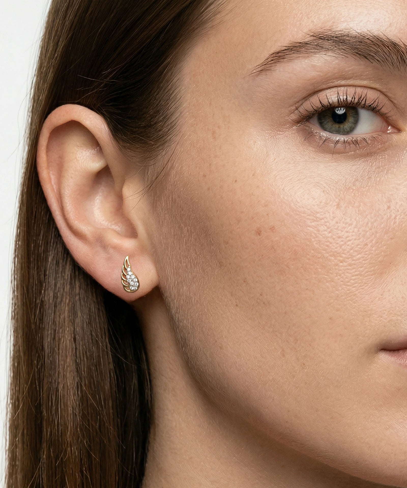 Close-up of a woman wearing a silver earring with a white background