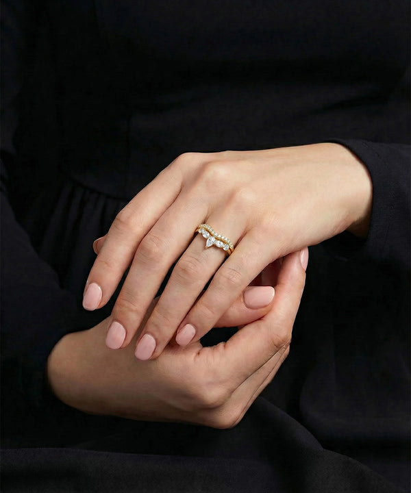 Close-up of hands with a gold ring on a dark background