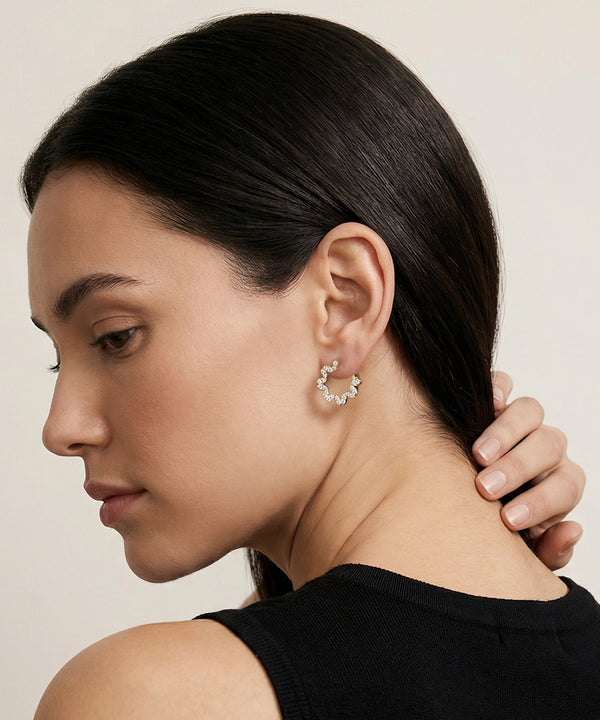 Woman wearing a delicate earring with a neutral background