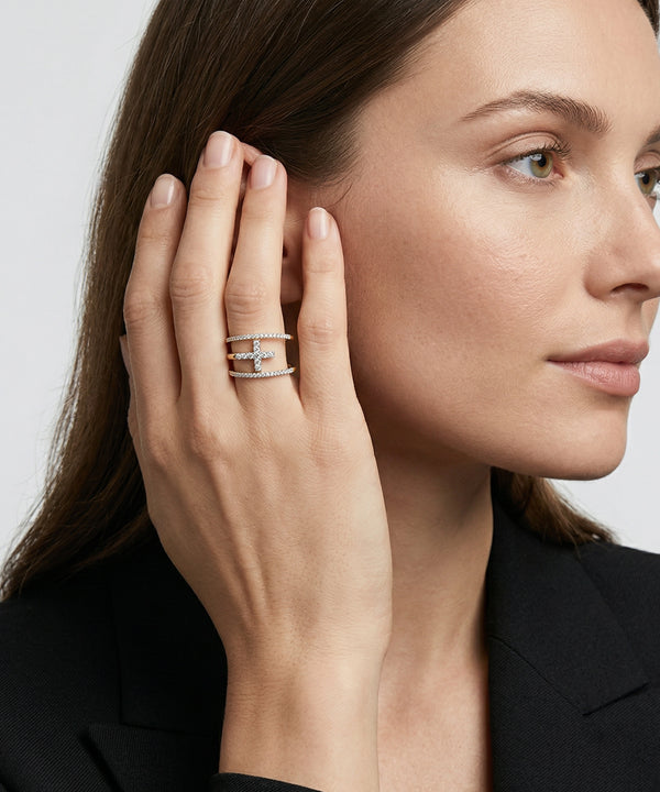 Woman wearing multiple rings on her hand with a neutral background
