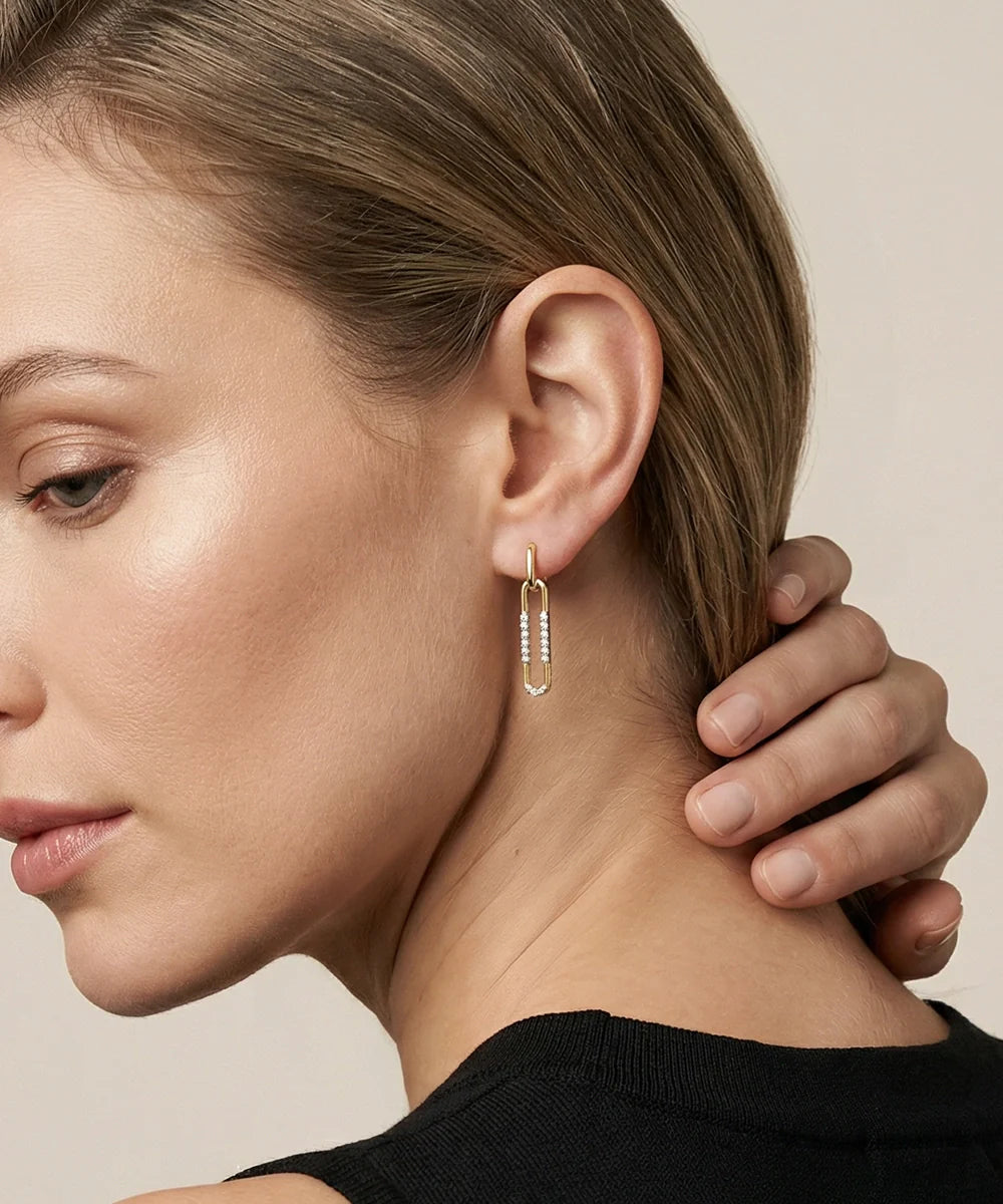Close-up of a woman wearing a silver earring with a neutral background