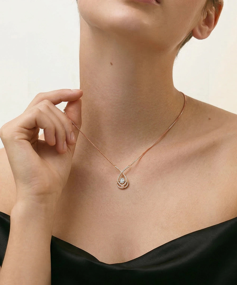 Rose gold necklace worn by a person against a neutral background