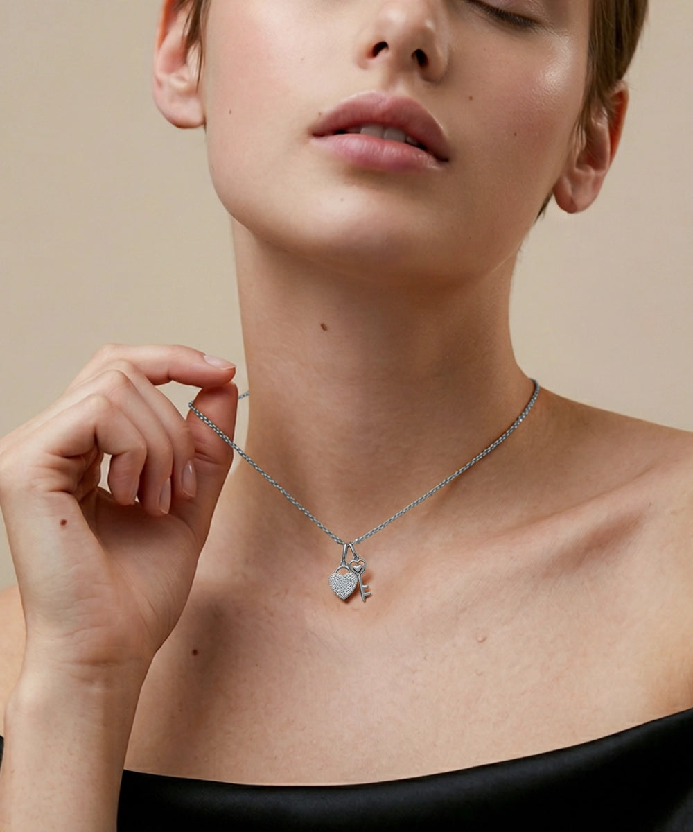 Person wearing a silver necklace with a heart pendant on a beige background
