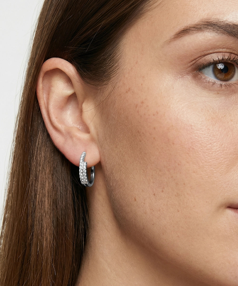 Close-up of a person wearing a silver hoop earring.