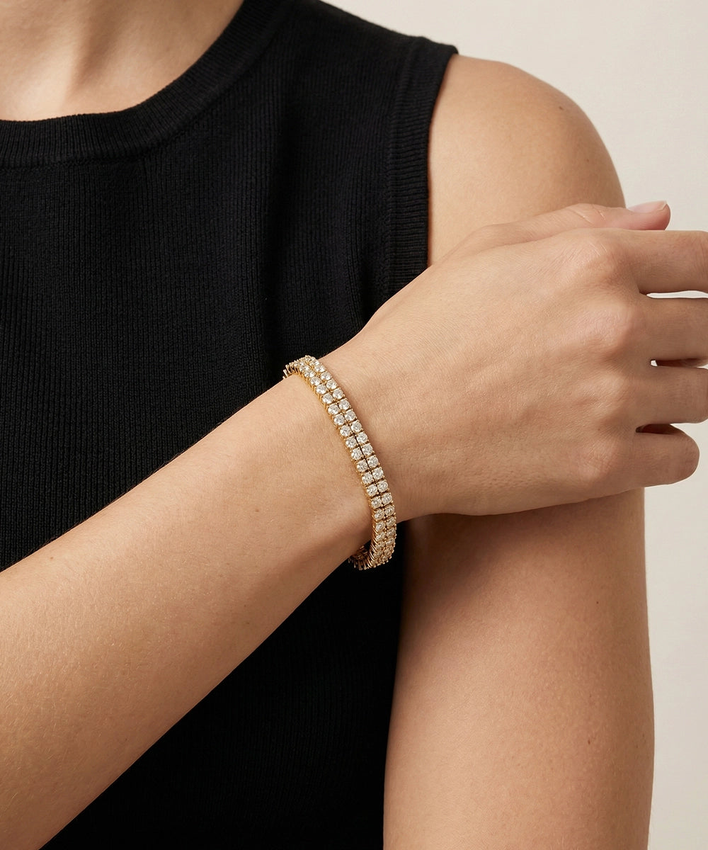 Person wearing a silver bracelet on a neutral background