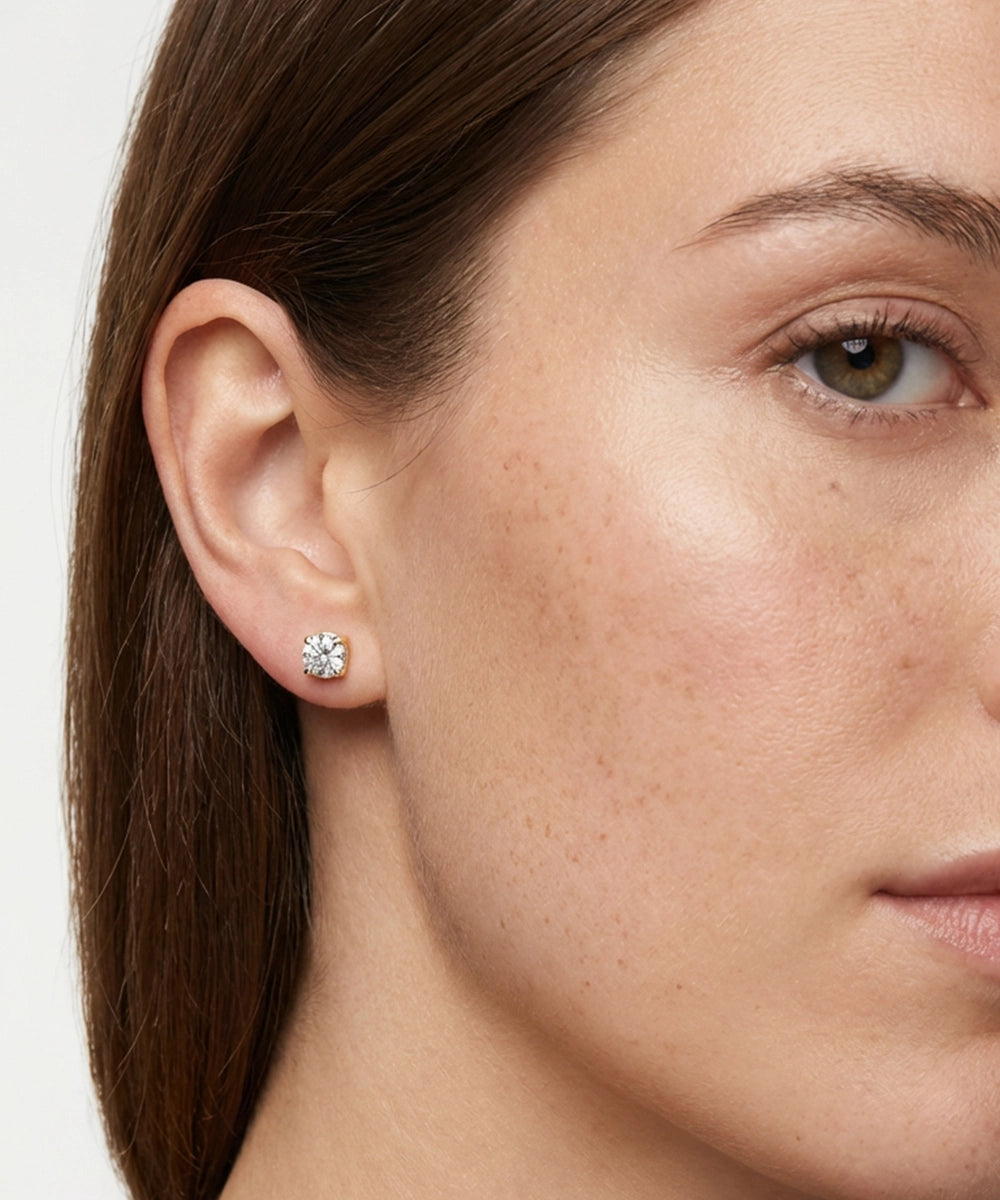 Close-up of a woman wearing a diamond earring on a white background