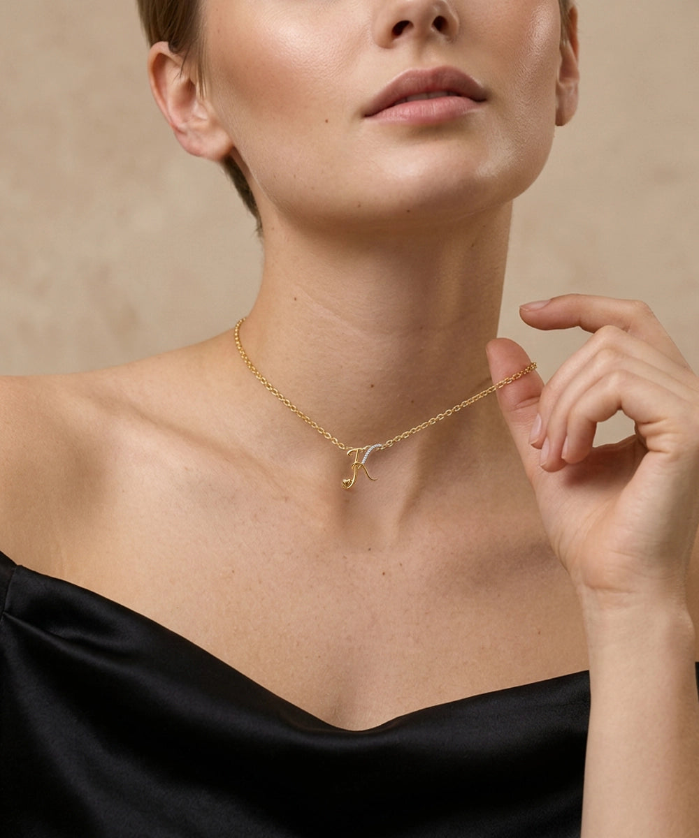 Woman wearing a gold necklace with a delicate chain design on a beige background