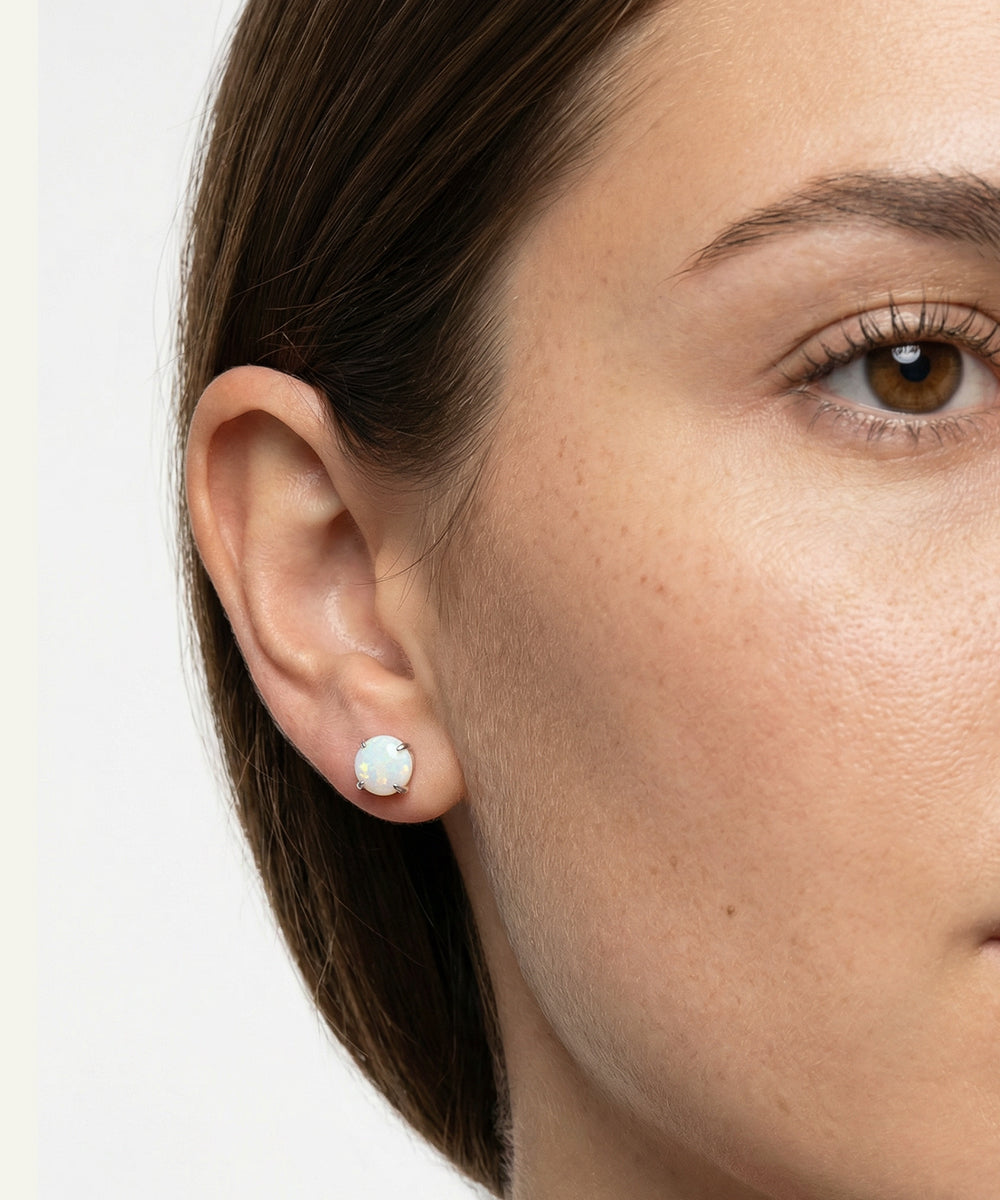 Close-up of a woman wearing a pearl earring on a white background