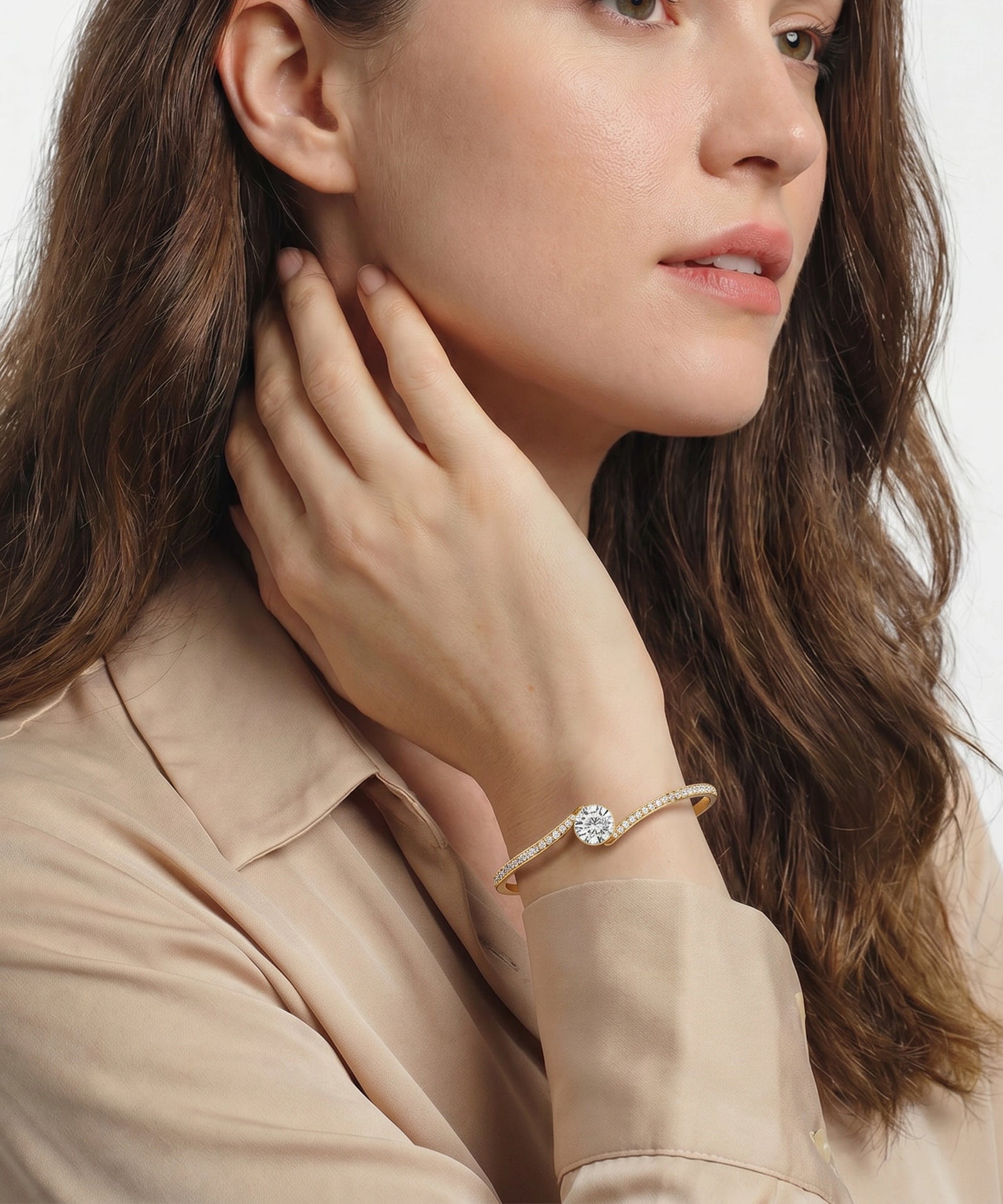 Woman wearing a bracelet with a diamond on a plain background