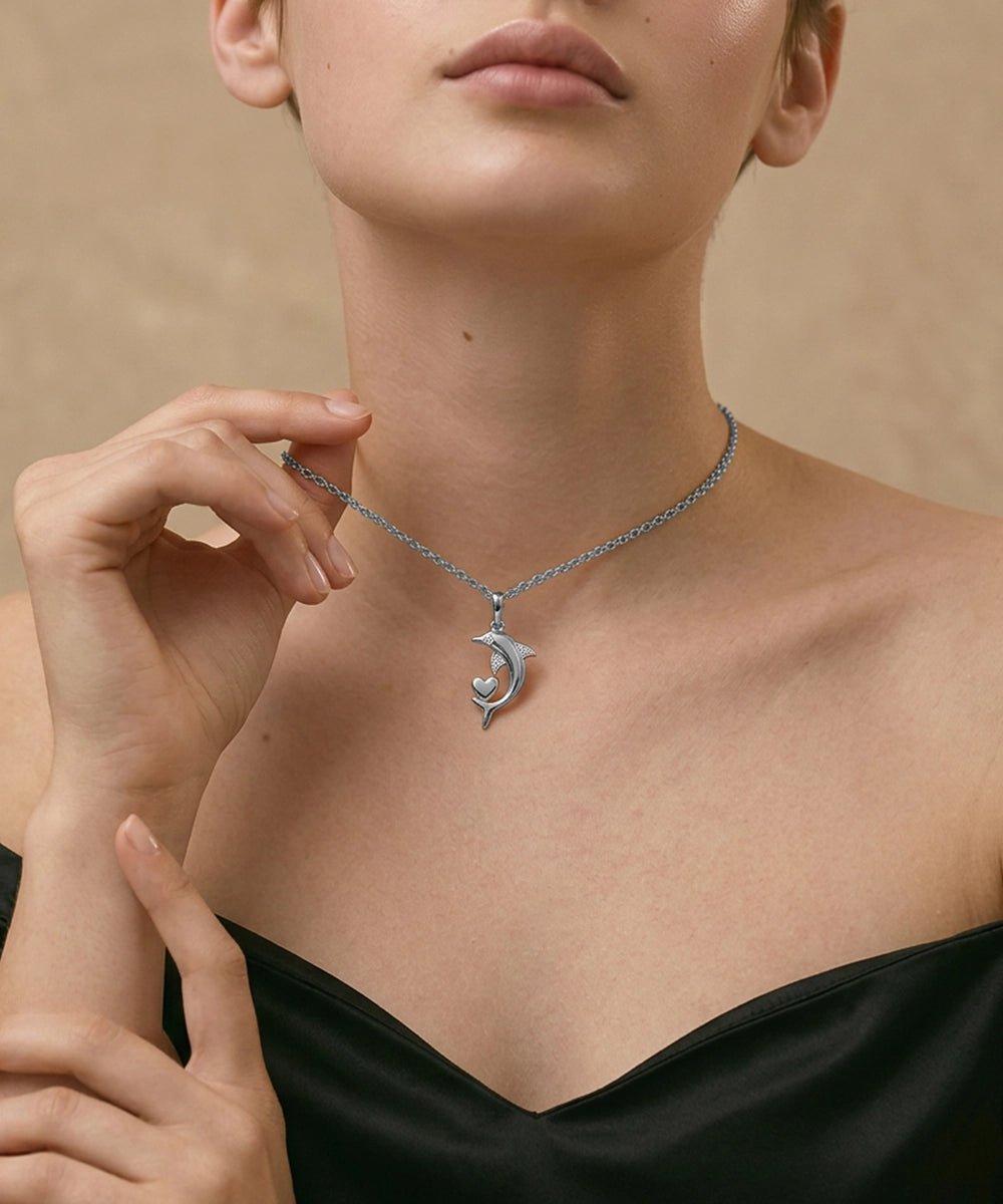 Woman wearing a silver necklace with a crescent moon pendant against a beige background