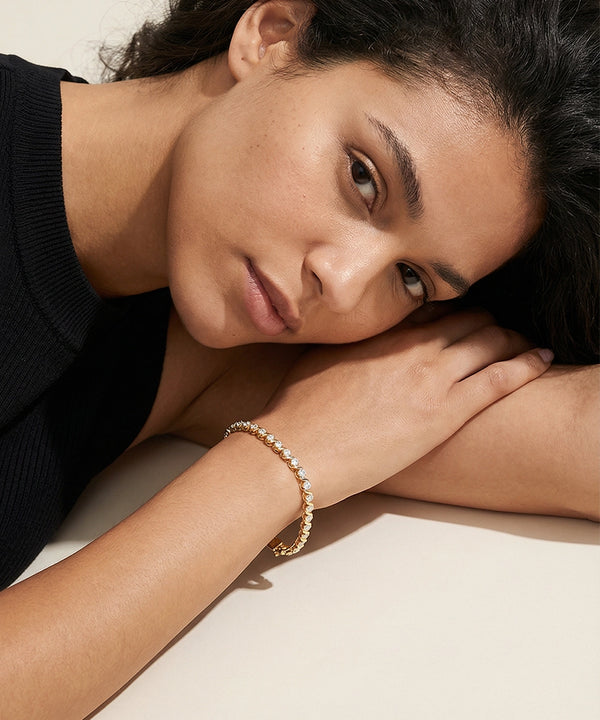 Woman wearing a bracelet with a neutral background