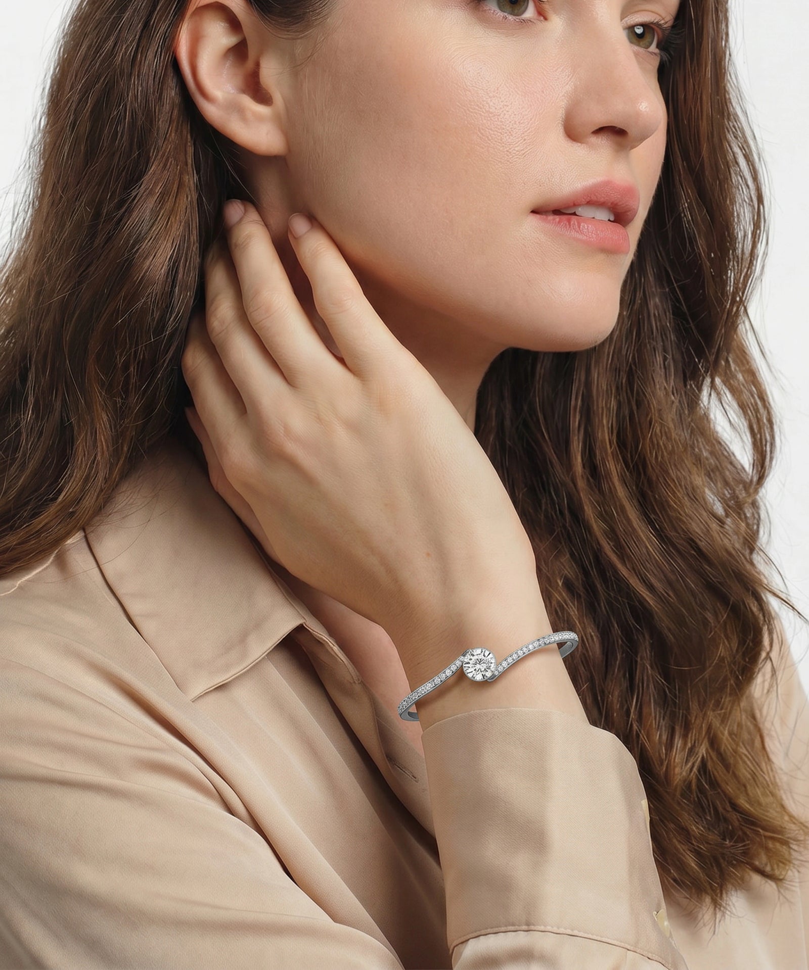 Woman wearing a bracelet with a diamond on a plain background