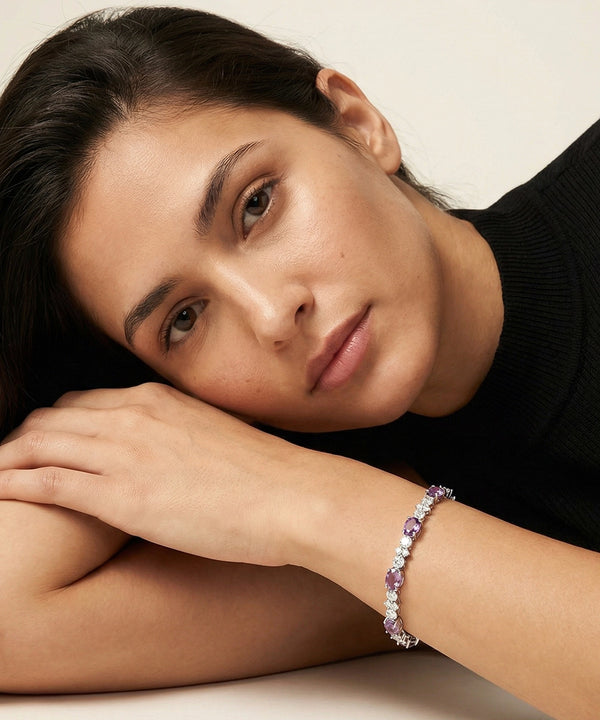 Woman wearing a bracelet with pink stones on a neutral background