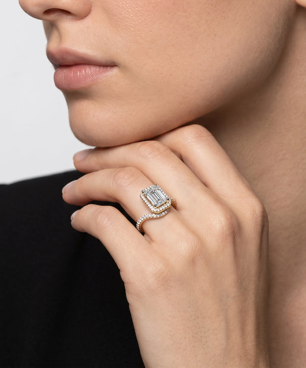 Close-up of a hand wearing a diamond ring with a blurred background
