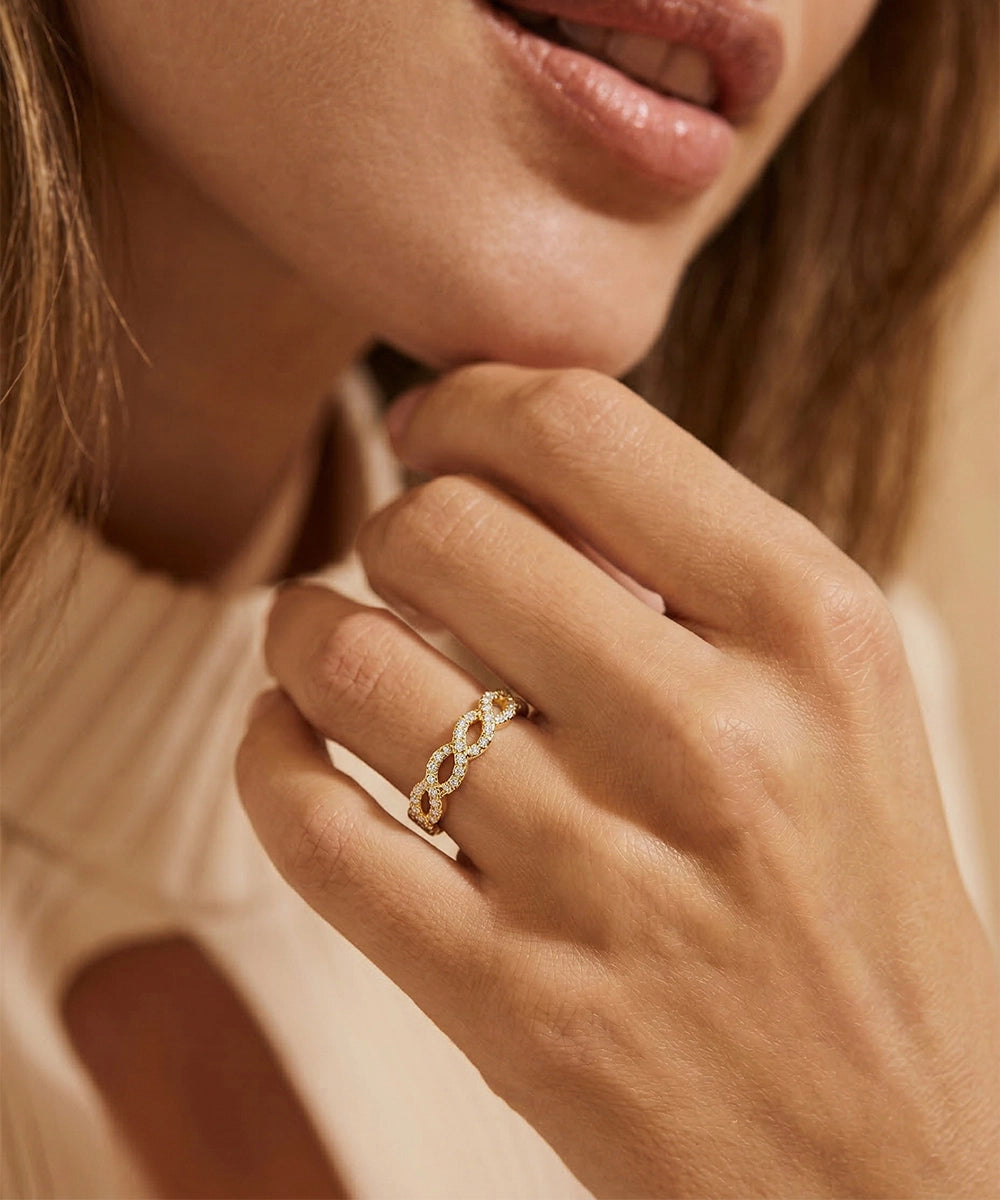 Close-up of a hand wearing a gold ring with a blurred background