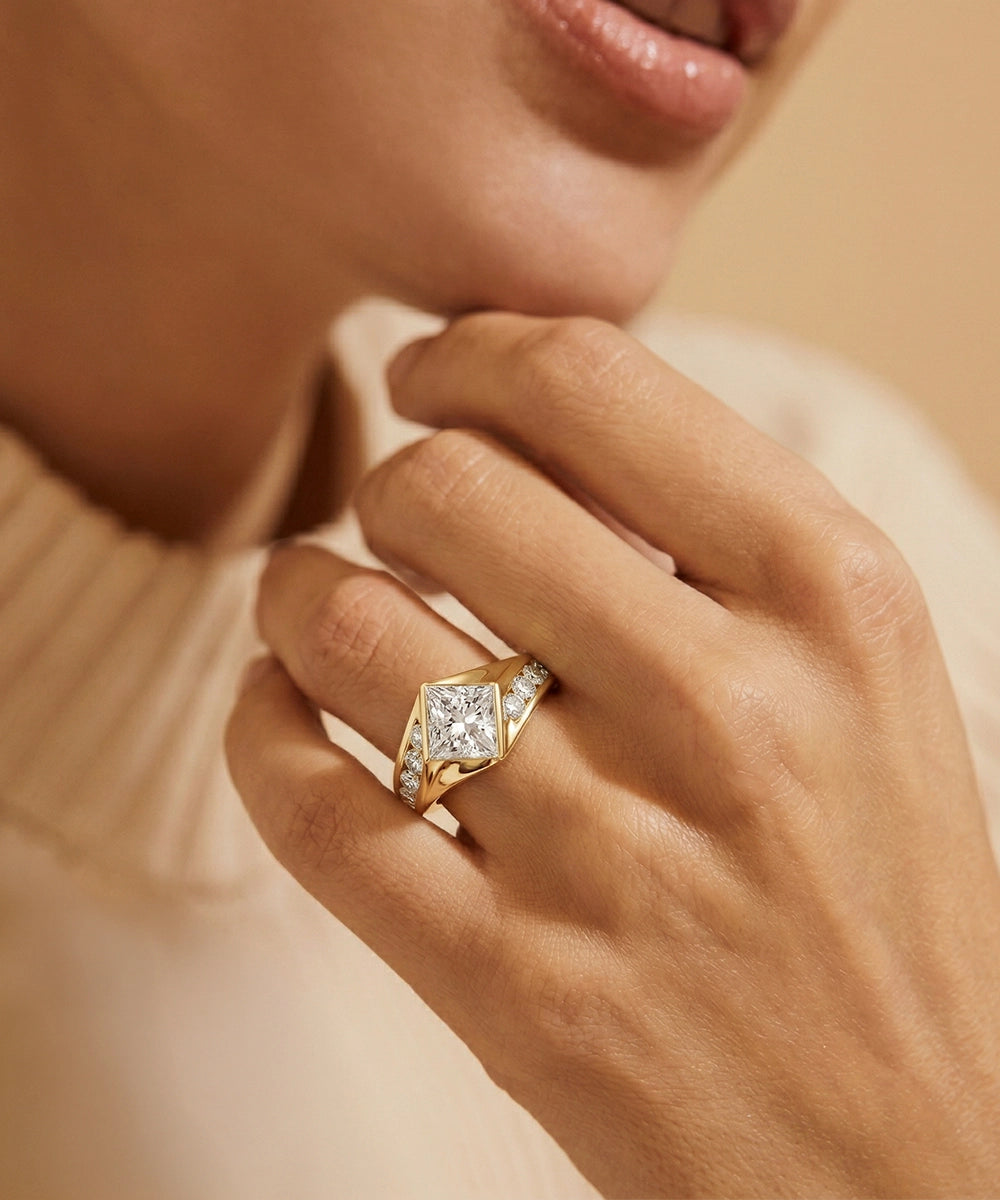 Gold ring with a diamond on a hand against a neutral background